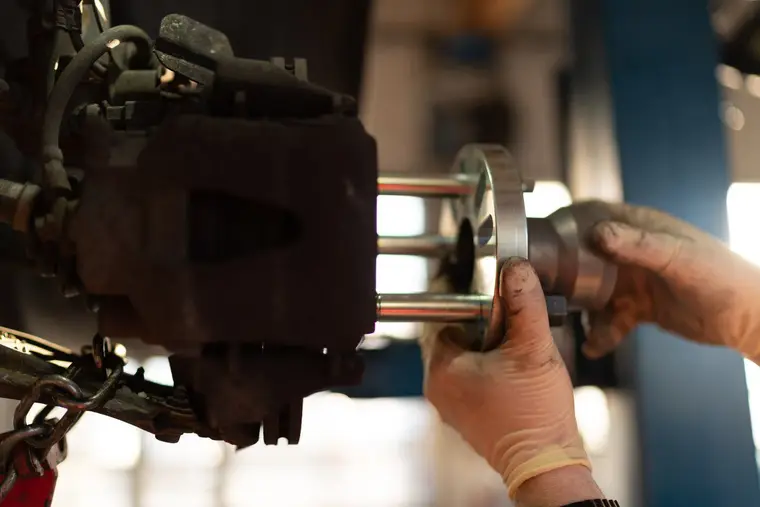 Ręce mechanika przy ściąganiu łożyska ściągaczem